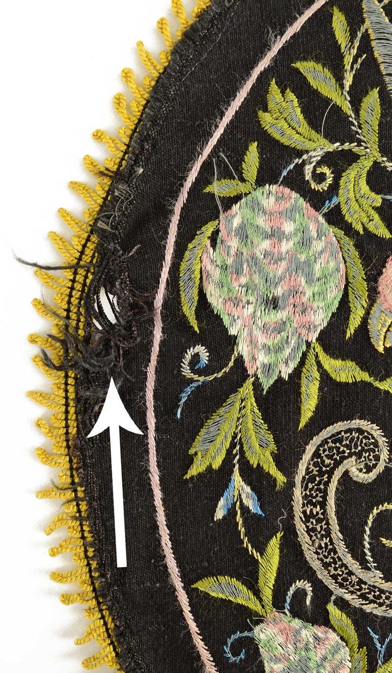 Antique embroidered parrot on perch.