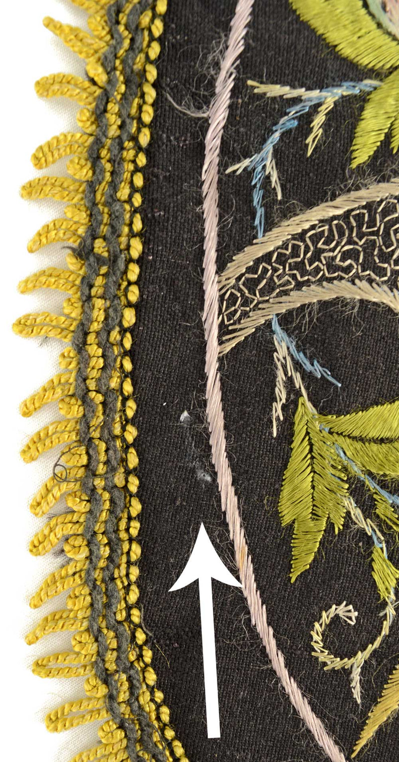 Antique embroidered parrot on perch.